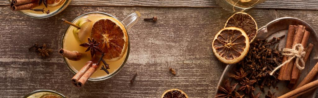 top view of traditional warm pear mulled wine with spices and dried citrus on wooden rustic table, panoramic shot - Photo, Image
