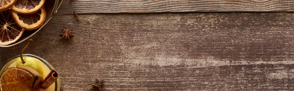 верхний вид горячего грушевого глинтвейна со специями и сушеными цитрусовыми на деревянный стол, панорамный снимок
 - Фото, изображение
