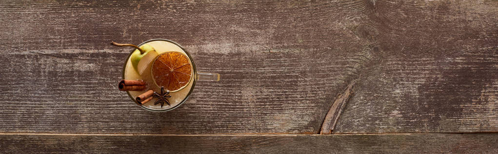 Baharatlı sıcak armut şarabı ve ahşap masada kurutulmuş narenciye. Panoramik çekim. - Fotoğraf, Görsel