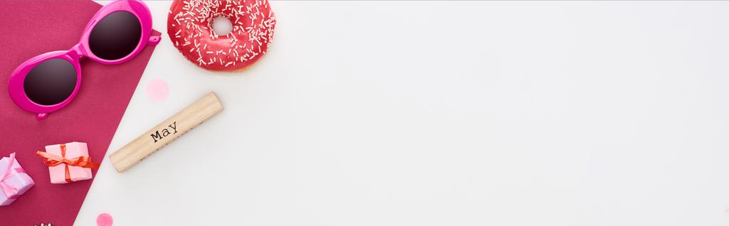 plano panorámico de bloque de madera con inscripción de mayo, rosquilla, gafas de sol, cajas de regalo, papel carmesí aislado en blanco
 - Foto, Imagen
