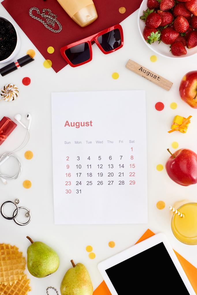 8月のカレンダーページ, 8月の碑文と木製のブロック,デジタルタブレット,サングラス,オレンジジュース,果物,ワッフル,化粧品,白い上に隔離されたイヤホン - 写真・画像