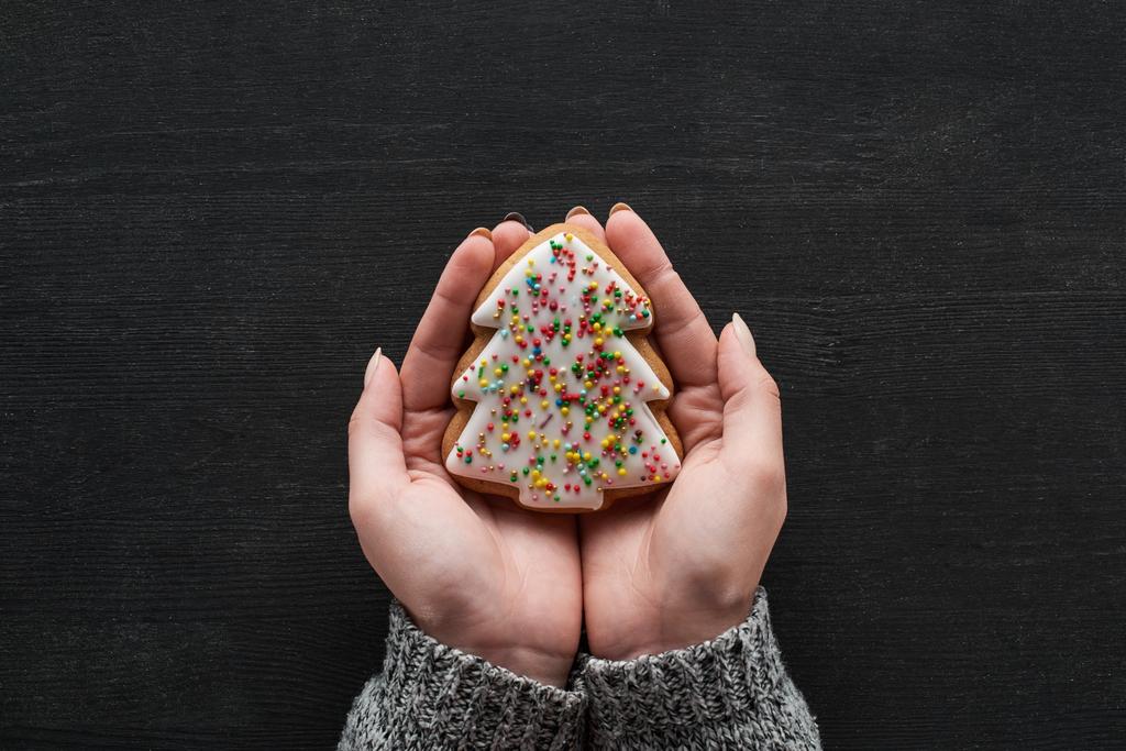 vista cortada de mulher segurando cozido Biscoito de árvore de Natal em mãos
 - Foto, Imagem