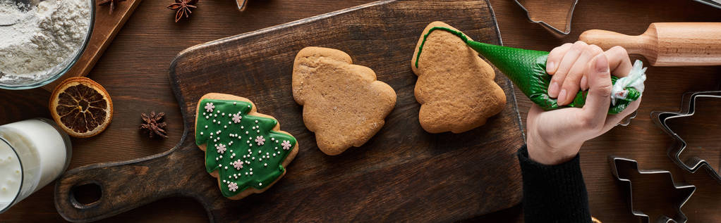木製のテーブルの上に女性の輝くクリスマスクッキーのクロップドビュー,パノラマショット - 写真・画像