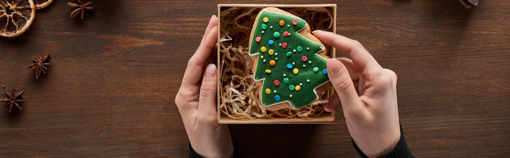 kivágott kilátás nő üzembe karácsonyfa süti ajándékdobozba fa asztal, panoráma lövés - Fotó, kép