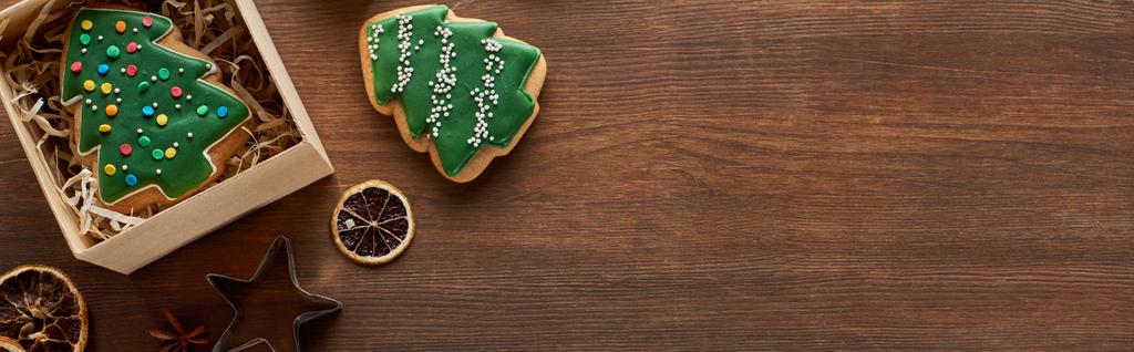 vista superior de galletas de árbol de Navidad, caja de regalo y rodajas de cítricos secos en la mesa de madera, plano panorámico, plano panorámico
 - Foto, imagen