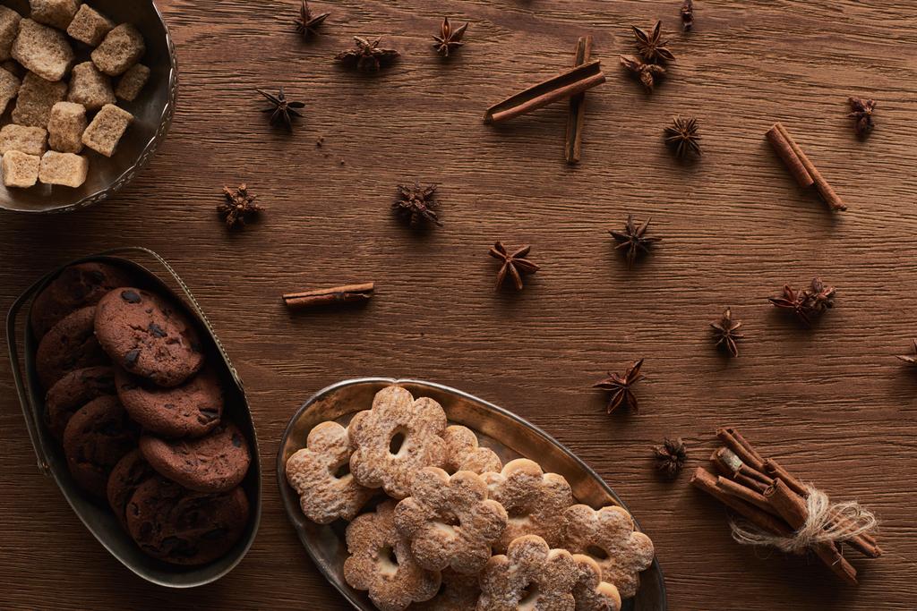 vrchní pohled na vánoční sušenky na dřevěném stole s anýzem a skořicí - Fotografie, Obrázek