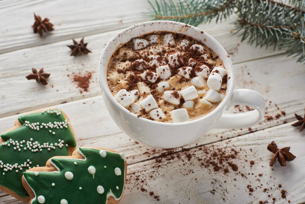 cacao with marshmallow in mug on white wooden table with fir branch and Christmas cookies - Fotó, kép