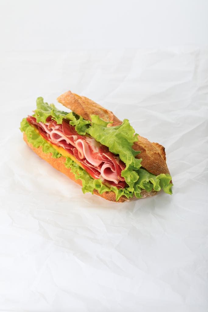sándwich fresco con lechuga, jamón, queso, tocino y tomate sobre fondo blanco texturizado
 - Foto, imagen