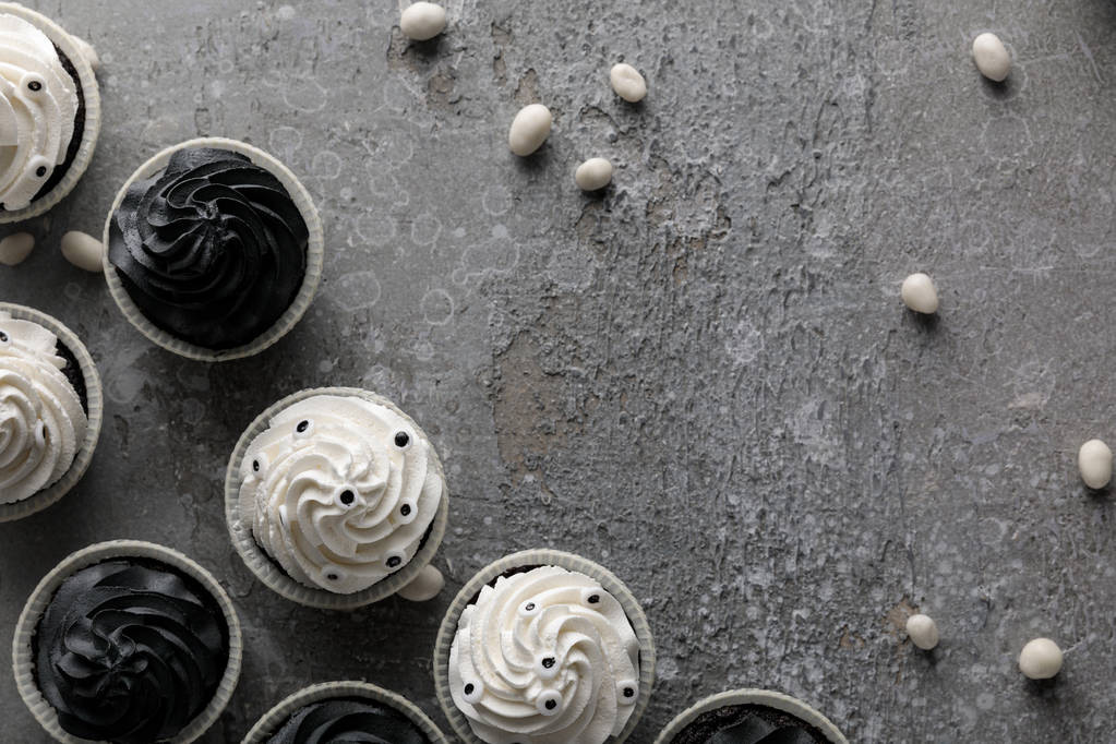 Beton gri yüzeyde leziz Cadılar Bayramı çörekleri ve tatlılarının üst görüntüsü - Fotoğraf, Görsel