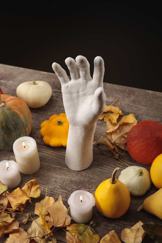 dry foliage, burning candles, ripe pumpkins and decorative hand on wooden rustic table isolated on black - Photo, Image