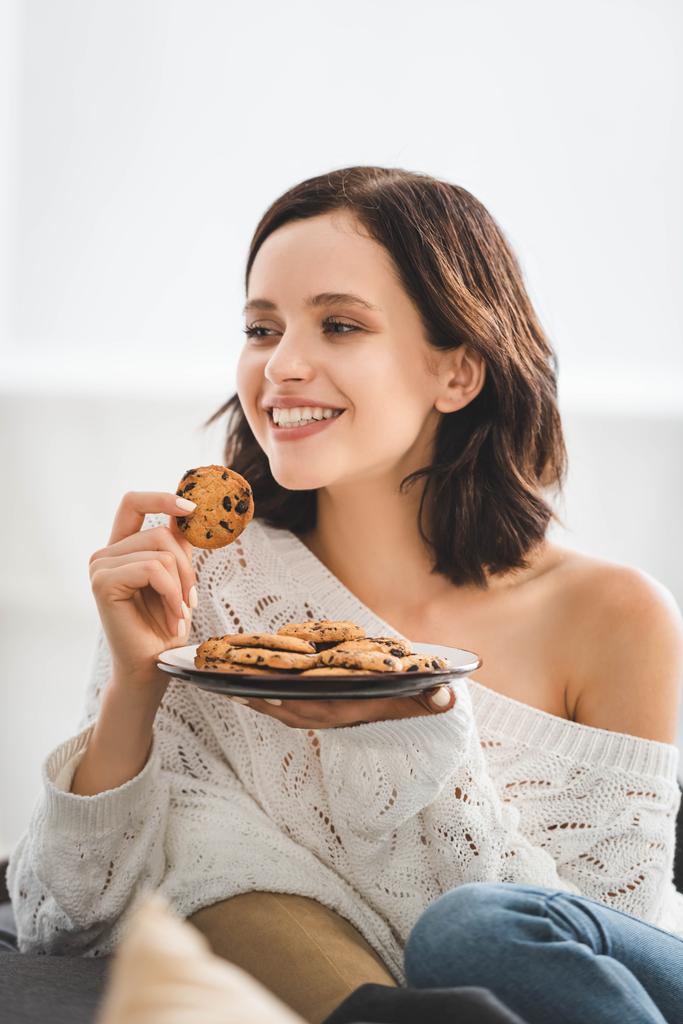 hermosa mujer feliz comiendo galletas en casa
 - Foto, Imagen