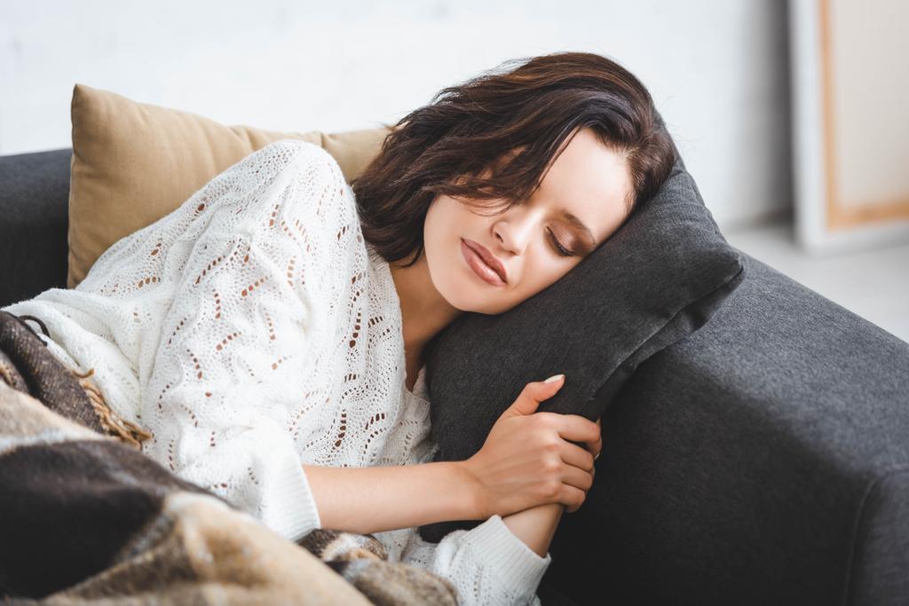 schöne junge Frau schläft in einer Decke auf dem Sofa  - Foto, Bild
