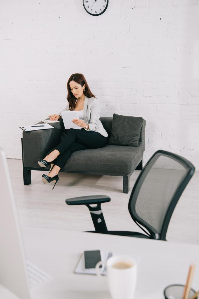 selektivní zaměření elegantní sekretářky pracující při sezení na gauči v kanceláři - Fotografie, Obrázek
