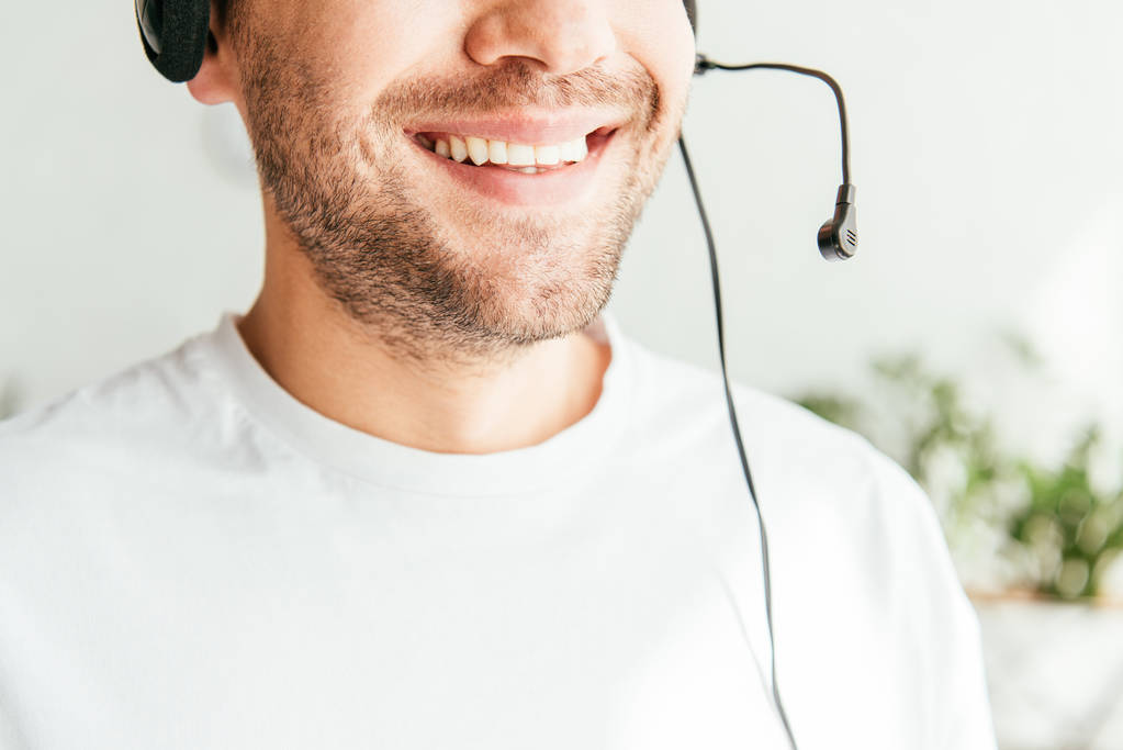 περικοπή άποψη του θετικού μεσίτη σε ακουστικά χαμογελώντας στο γραφείο  - Φωτογραφία, εικόνα