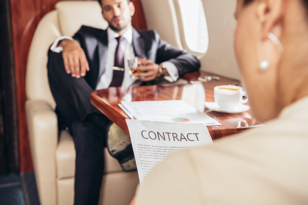 民間航空機で契約書を読むビジネスマンの選択的焦点  - 写真・画像