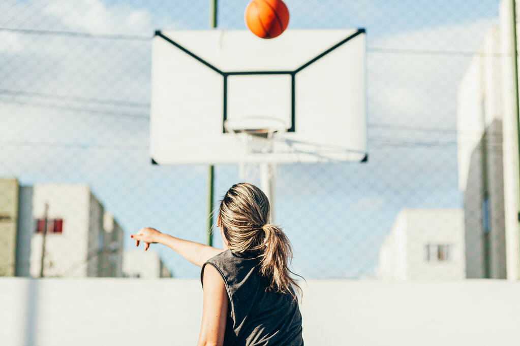 Genç bayan basketbolcu yerel bir sahada antrenman yapıyor. - Fotoğraf, Görsel