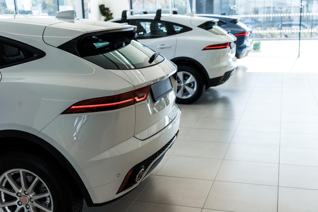 selective focus of white shiny cars in car showroom  - Photo, Image