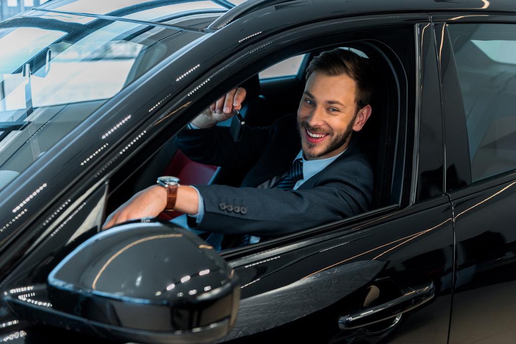 valikoiva painopiste onnellinen parrakas mies jolla auton avain kun istuu autossa
  - Valokuva, kuva