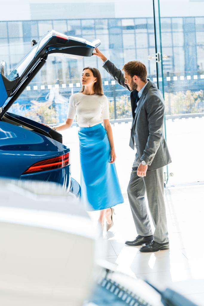enfoque selectivo de la hermosa mujer y el hombre de pie cerca de coche azul
  - Foto, imagen