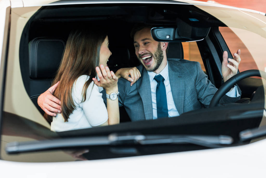 valikoiva painopiste innoissaan parrakas mies katselee naista ja elehtii autossa
  - Valokuva, kuva