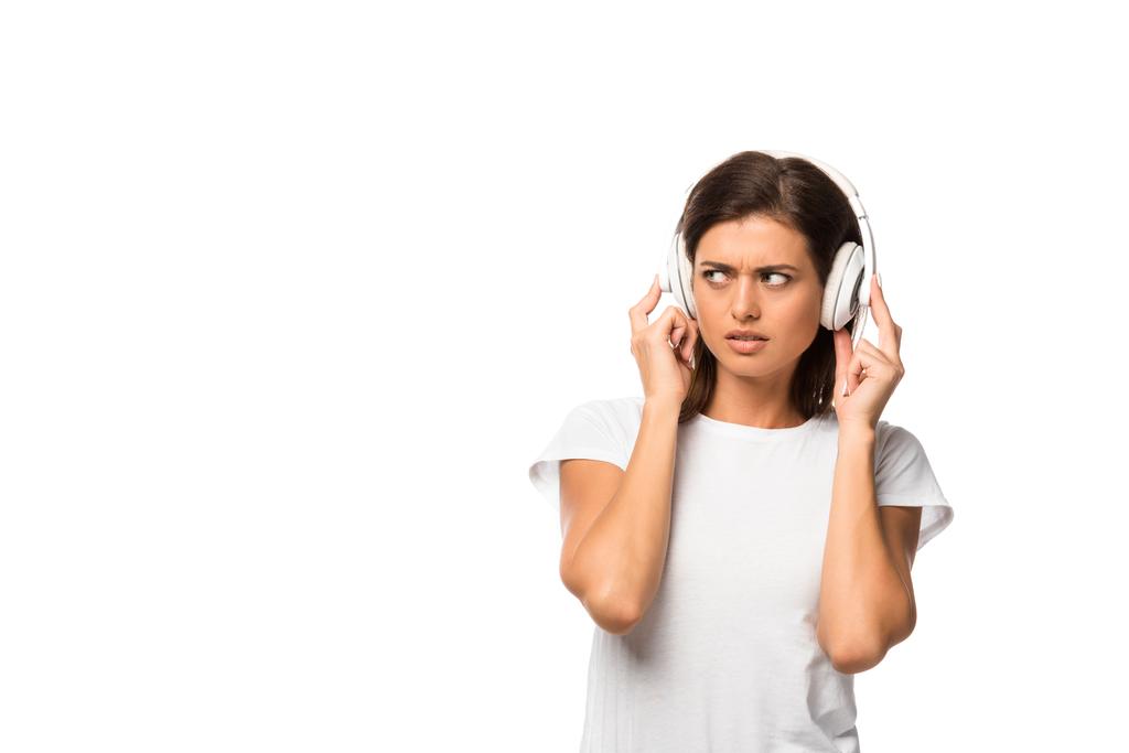 mujer hermosa frustrada escuchando música con auriculares, aislado en blanco
 - Foto, Imagen