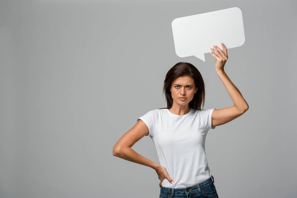 beautiful angry woman holding empty speech bubble, isolated on grey - Photo, Image