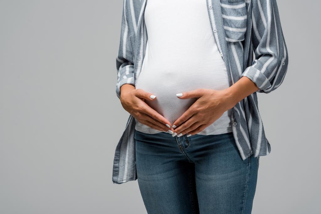 recortado vista de embarazada chica tocando vientre aislado en gris
 - Foto, Imagen
