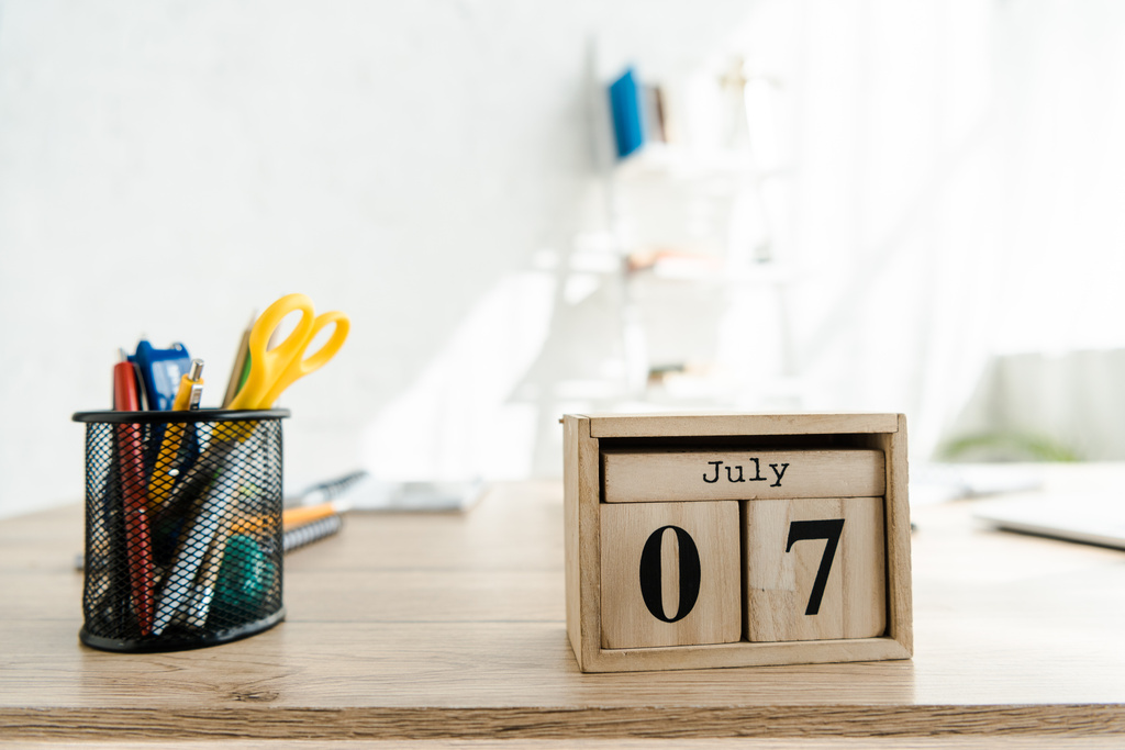 закрытие деревянного календаря на столе в светлом современном офисе
 - Фото, изображение
