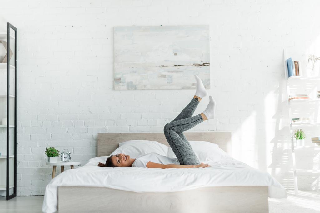 gyönyörű boldog lány fekszik az ágyon a világos hálószobában - Fotó, kép