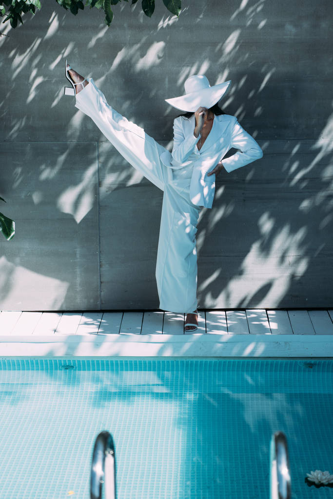 femme adulte en costume blanc et chapeau posant à l'extérieur
  - Photo, image