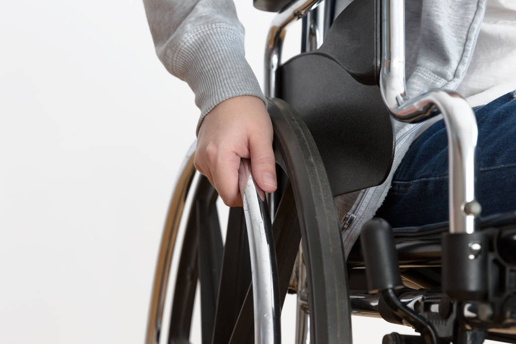 車いすの上で手を握る障害者女性の詳細 - 写真・画像