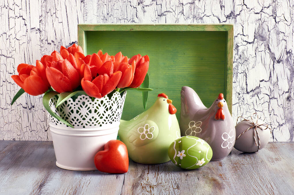 Composición de Pascua con tulipanes rojos; gallinas de cerámica y huevos de Pascua
 - Foto, Imagen