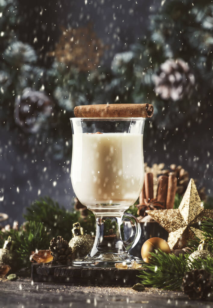 Різдвяний або новорічний яєчний алкогольний коктейль - гарячий зимовий напій з молоком, яйцями та ромом, посипаний корицею та мускатним горіхом у склянці на сірому фоні, місце для тексту
 - Фото, зображення