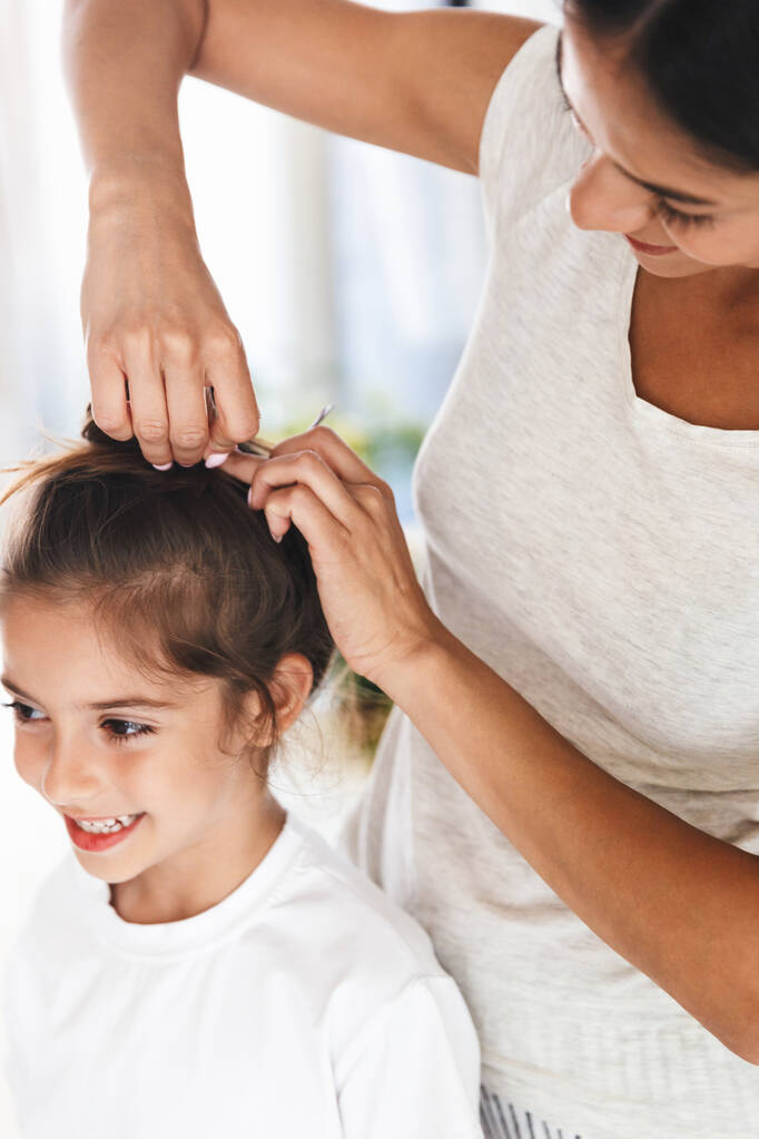 Genc aile kadininin topuzsuz saç modelini yaparken tam boy goruntusu - Fotoğraf, Görsel