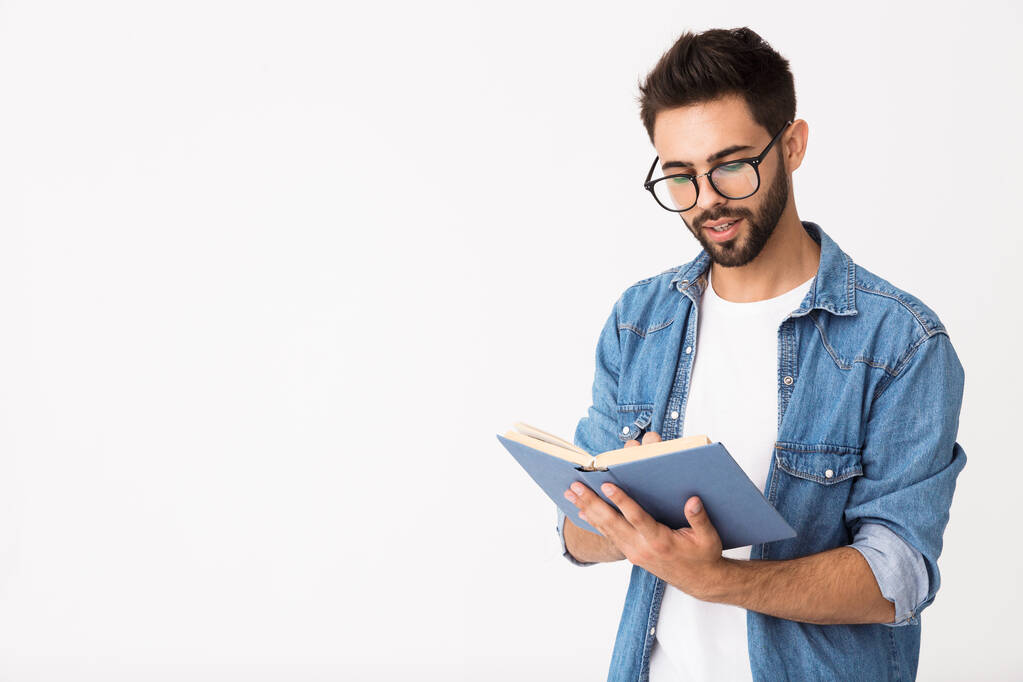 Bild eines kaukasischen intelligenten Mannes mit Brille, der ein Buch hält und liest - Foto, Bild