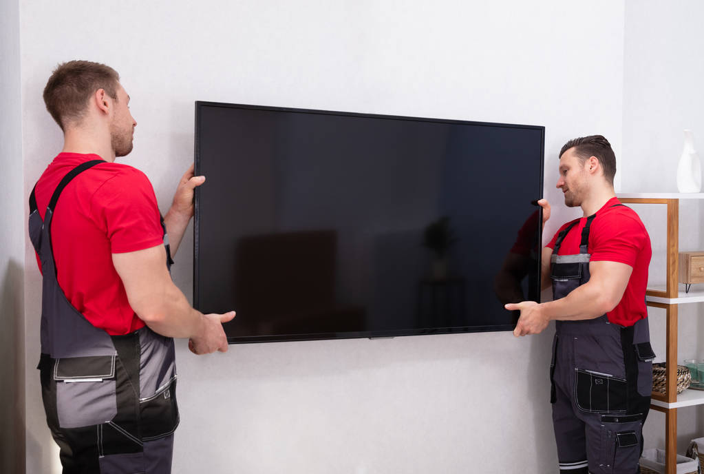 Μετακινητές που καθορίζουν το μεγάλο επίπεδο LCD τηλεόραση στον τοίχο στο σαλόνι - Φωτογραφία, εικόνα