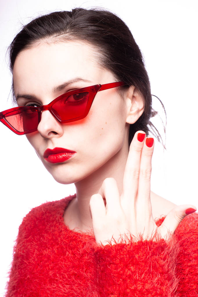 赤いサングラス赤い口紅赤いセーターの若い女性は - 写真・画像