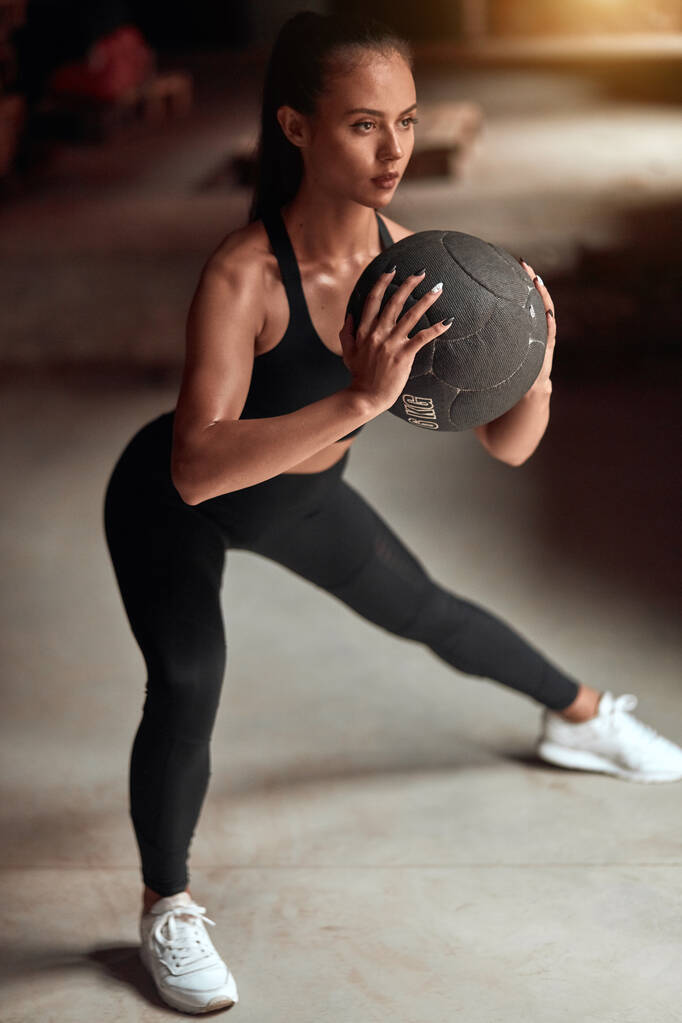 sportos fiatal nő gyakorló sqauts labdával az edzőteremben - Fotó, kép