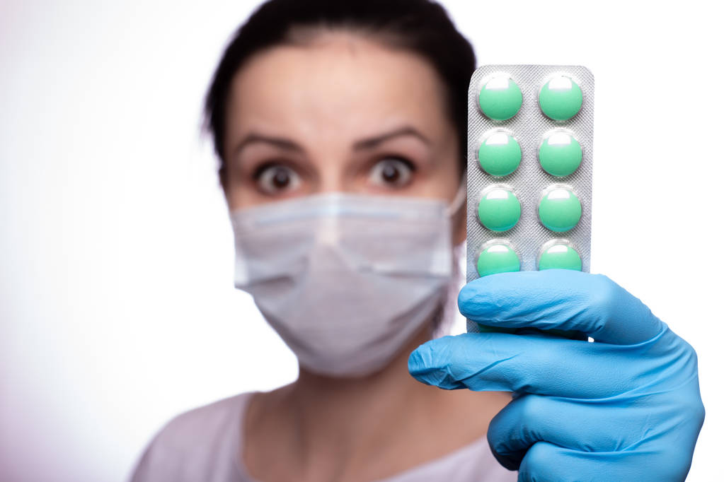 fiatal nő egy orvosi mák és kesztyű egy tablettával - Fotó, kép