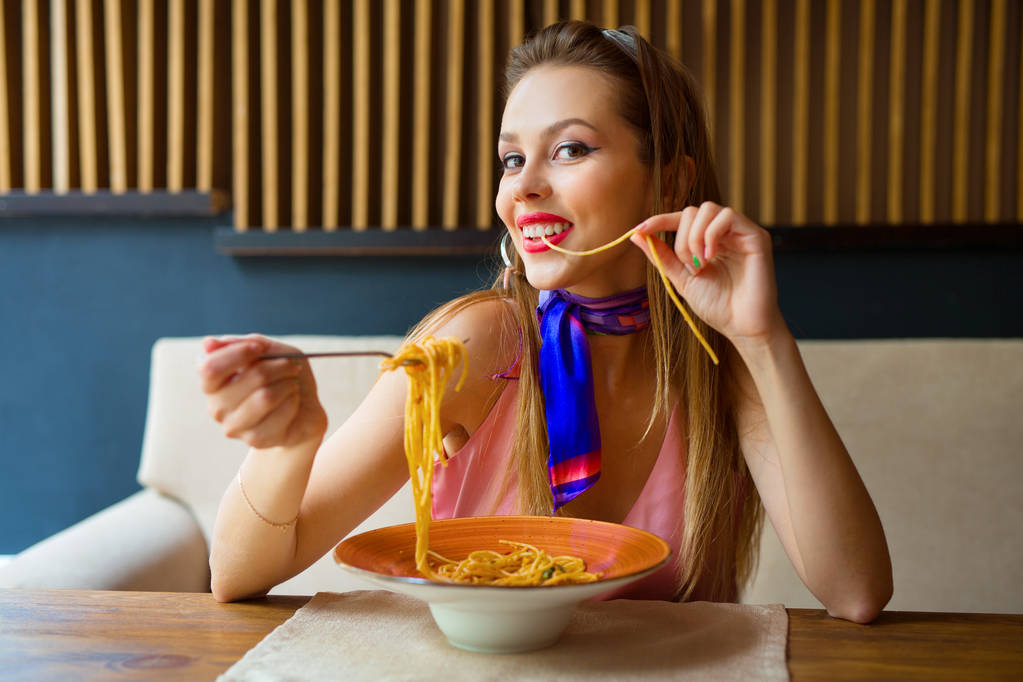 красивая девушка с макияжем ест спагетти в ресторане
 - Фото, изображение