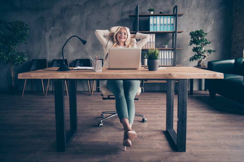 Photo of happy cheerful positive company leader boss wearing heeled shoes glasses holding head with hands enjoying her free time at work - Photo, Image