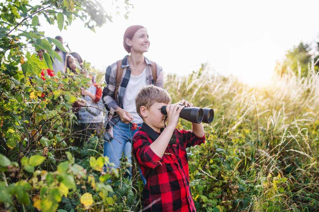 Group of school children with teacher on field trip in nature, using binoculars. - Photo, Image