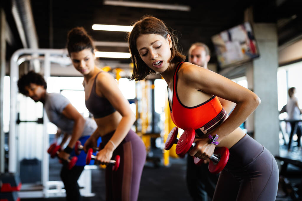 Счастливые здоровые люди занимаются спортом, тренируются в тренажерном зале, чтобы оставаться здоровыми вместе - Фото, изображение