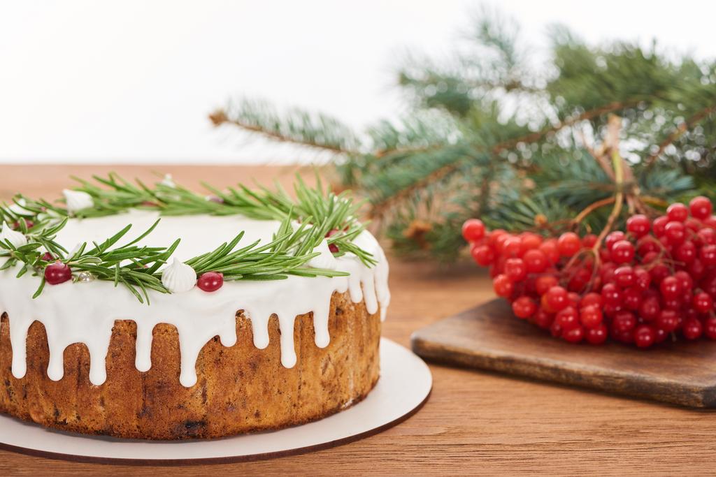 kersttaart met rozemarijn en viburnum bessen op houten tafel met sparren takken - Foto, afbeelding