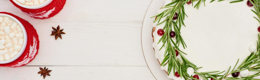 vrchní pohled na dva šálky kakaa a sladký vánoční koláč na bílém dřevěném stole  - Fotografie, Obrázek