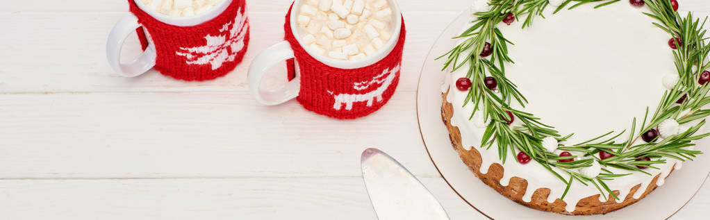 top view of christmas pie with rosemary and two cups of cocoa with marshmallows on white wooden table    - Photo, Image