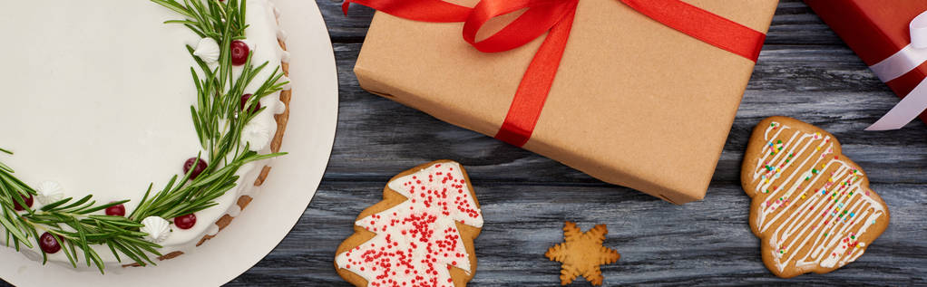 вид зверху на різдвяний пиріг, солодке печиво та подарункові коробки на темному дерев'яному столі
 - Фото, зображення