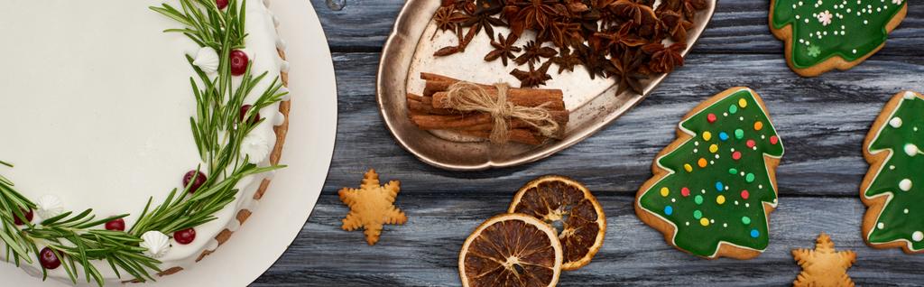 クリスマスパイとスパイスとクリスマスツリーのクッキーをダークウッドのテーブルの上から - 写真・画像