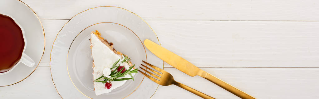 vista superior del pedazo de pastel de Navidad, té, tenedor y cuchillo en la mesa de madera blanca
 - Foto, Imagen
