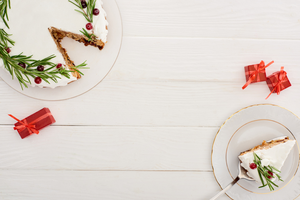 вид на рождественский пирог на белом деревянном столе с маленькими подарками
 - Фото, изображение
